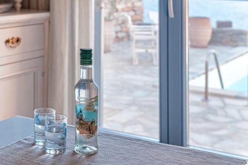 OtziásにあるKEA'S VILLAのグラス2枚付きテーブルに座るボトル