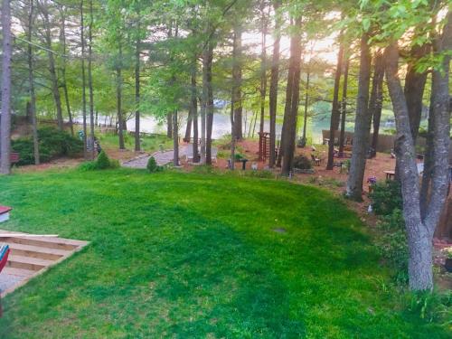 a green yard with trees and a field of grass at Clear Pond Suite in Plymouth