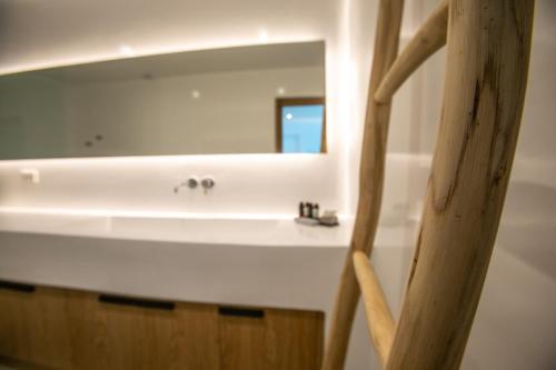 a bathroom with a white sink and a mirror at Melidonia Suites in Akrotiri