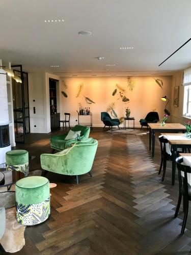 a restaurant with green chairs and tables and tables at Alpenloge Design Hotel in Scheidegg