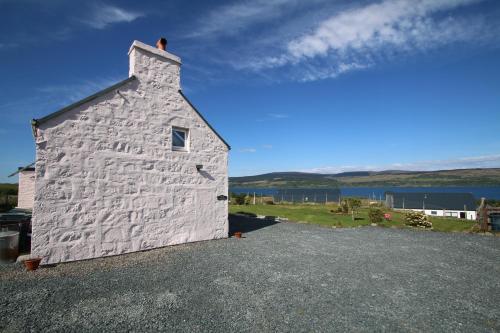 a white building sitting on top of a hill at Arle Farmhouse in Tobermory