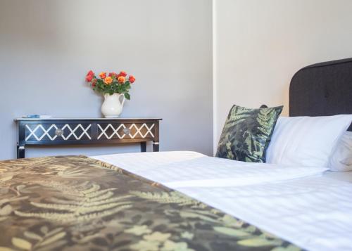 a bedroom with a bed and a vase with flowers at Boutique-Hotel Weigels Bergfreiheit in Winterberg