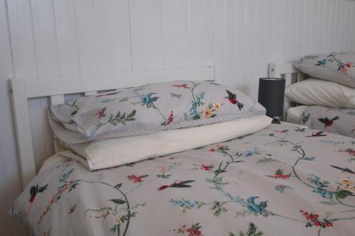 a bed with a white bedspread with flowers on it at Arle Farmhouse in Tobermory