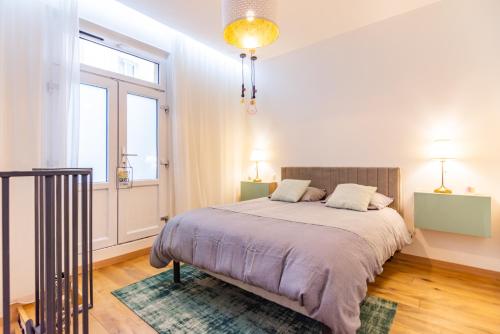 a bedroom with a bed and a large window at Superbe loft en plein Paris in Paris