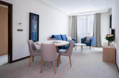 a living room with a dining room table and chairs at Golden Tulip Royaume in Alger