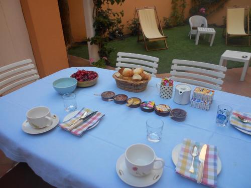 einem blauen Tisch mit Tassen und einem Korb mit Essen in der Unterkunft Maison de Pêcheur in Toulon