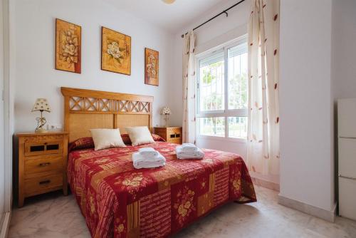 - une chambre avec un lit et 2 serviettes dans l'établissement Playa del Cantil, 3 bedrooms and 2 free parking, à Isla Cristina
