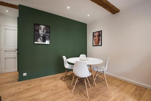 une table et des chaises dans une pièce dotée d'un mur vert dans l'établissement APPARTEMENT 2 NEUF sur le port à coté de la plage, à Saint-Raphaël