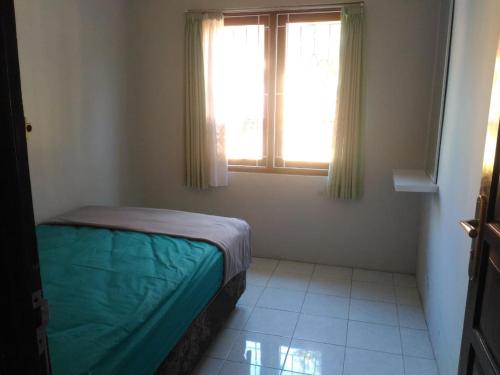 ein kleines Schlafzimmer mit einem Bett und einem Fenster in der Unterkunft Herry Home Stay_Jogja in Yogyakarta