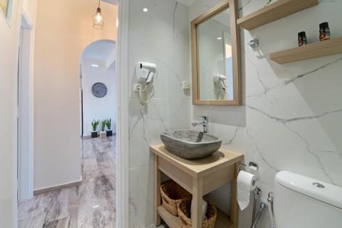 uma casa de banho com um lavatório e um espelho em Plakias Family Apartment em Plakiás