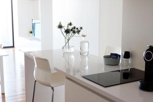 a white counter with a vase of flowers on it at Oh! Porto Apartments in Vila Nova de Gaia