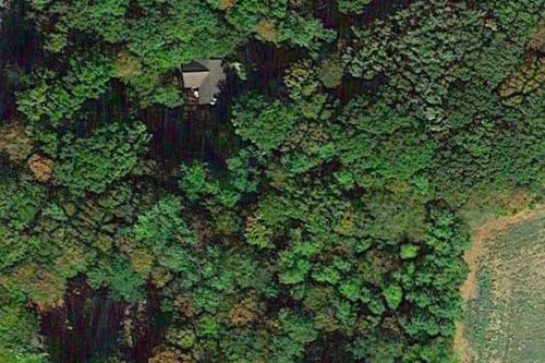 an overhead view of a forest with a house in the middle at Holy Wood in Chuelles
