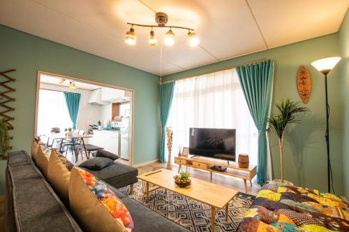 a living room with a couch and a tv at Villent Kujukuri Ocean 1 in Kujukuri