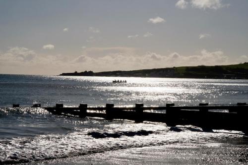 a pier on the beach with a boat in the water at Grand Hotel Swanage in Swanage