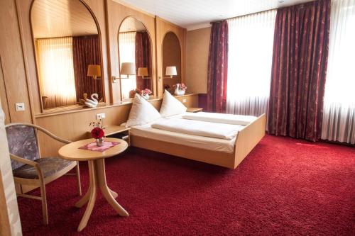Hotel Nassauer Hof في Wissen: غرفه فندقيه بسرير وطاولة وكرسي