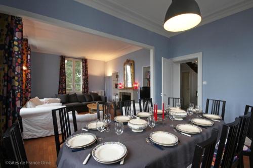 uma mesa de jantar com pratos e copos de vinho em Normandie 12 couchages em LʼAigle