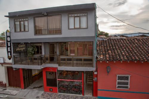 a red building with a store on a street at Hotel Casa Aragon in Cartago