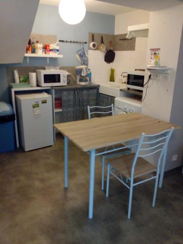 una cucina con tavolo in legno e 2 sedie di La maison des remparts a Lectoure