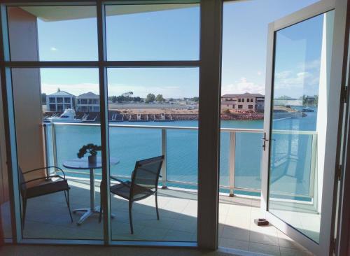 a balcony with a table and chairs and a view of the water at Wallaroo Marina Executive Apartments in Wallaroo