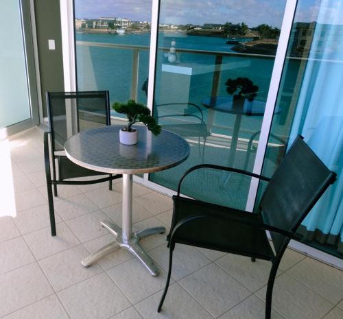 a table and chairs on a balcony with a view of the water at Wallaroo Marina Executive Apartments in Wallaroo