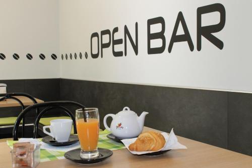 a table with a teapot and a cup of orange juice at Lepetit Milano in Milan