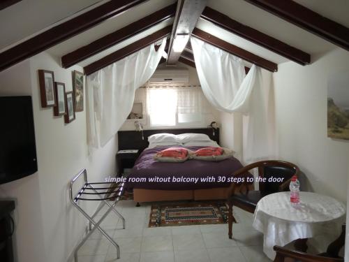 una piccola stanza con un letto e una finestra di Arbel Guest House Shavit Family ad Arbel