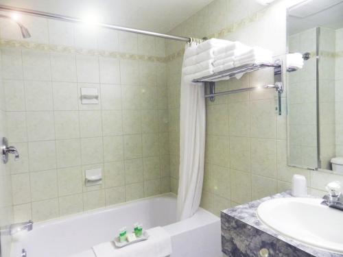 ein Badezimmer mit einer Badewanne, einem Waschbecken und einem WC in der Unterkunft Capri Inn in St. Catharines