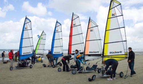 a group of people working on sailboats on the beach at Vakantiewoning Ouddorp - kindervriendelijk in Ouddorp
