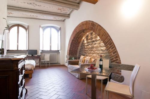 a living room with a couch and a brick fireplace at La Corte Del Re in Arezzo