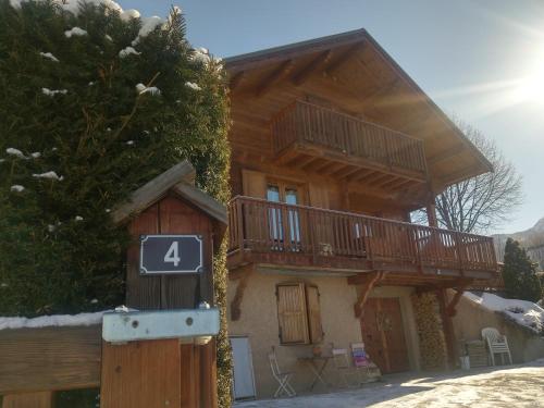 a large wooden house with a deck on it at La Carline in Guillestre