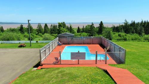 a large swimming pool in a field with a fence at Hopewell Rocks Motel & Country Inn in Hopewell Cape