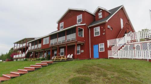 a large red building with steps in front of it at Hopewell Rocks Motel & Country Inn in Hopewell Cape