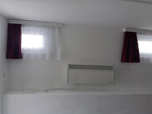 a white room with a radiator and a window at Guest House Baranin Pitomine in Žabljak