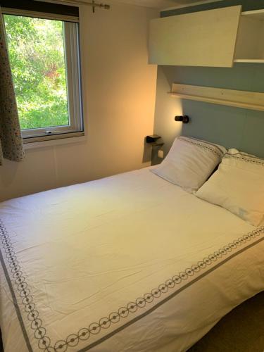 Camping Manaysse في موستيه سانت ماري: غرفة نوم مع سرير أبيض كبير مع نافذة