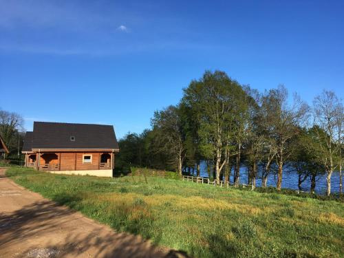 ein Haus auf einem Hügel neben einem Wasserkörper in der Unterkunft Au bord du lac III in Montigny-en-Morvan