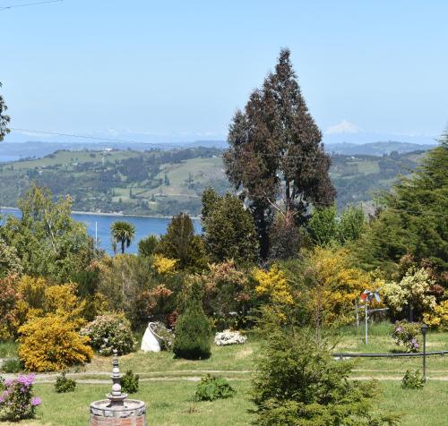 a view of a garden with a lake in the background at Cabañas Vista Tranquila Chiloé in Castro