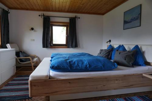 a bedroom with a large bed with blue sheets at Bauernhaus Heisenbauer in Neukirchen am Großvenediger
