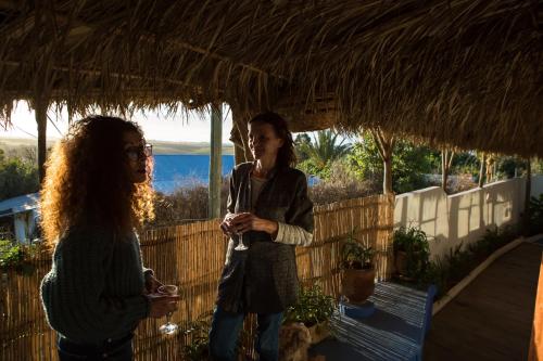 two women standing under a straw roof at Maison d'hotes Berbari in Asilah