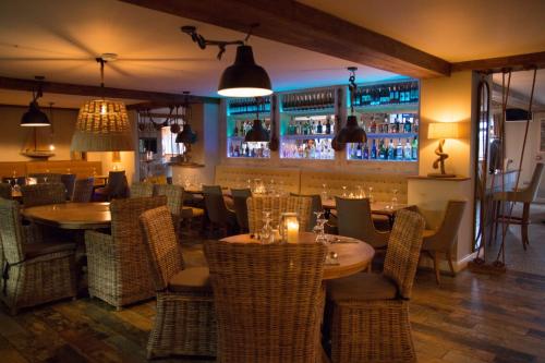 un restaurante con mesas y sillas y un bar en The Dunes Hotel en Barrow in Furness