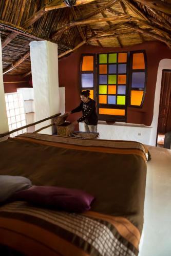 a man standing in front of a room with a bed at Maison d'hotes Berbari in Asilah