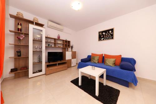 a living room with a blue couch and a table at Apartments Anka in Rtina