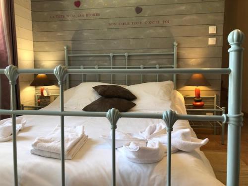 un lit avec des draps blancs et des serviettes dessus dans l'établissement Domaine de Label, Spa, massages, à La Salvetat-sur-Agout