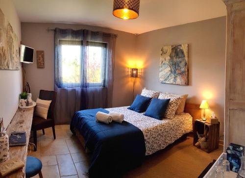 La Villa Esterel & SPA في Village-Neuf: غرفة نوم مع سرير ووسائد زرقاء