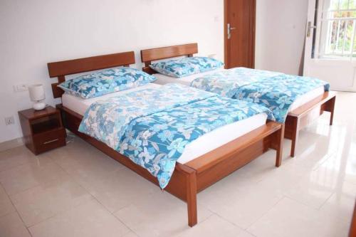 two twin beds in a room with at Hôtel Maisons-Sifa in Butare
