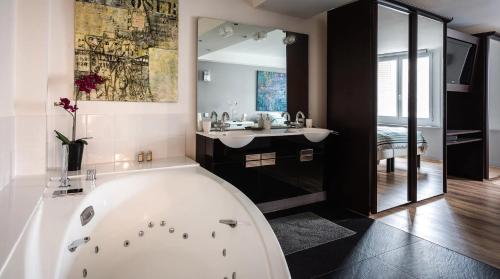 a bathroom with a tub and a sink and a bath tub at Le Notre Dame - Luxury Apartment with Seine View in Paris