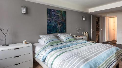 a bedroom with a bed and a painting on the wall at Le Notre Dame - Luxury Apartment with Seine View in Paris