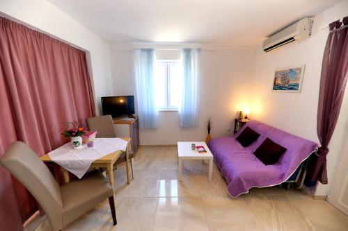 a living room with a purple couch and a table at Apartments Anka in Rtina