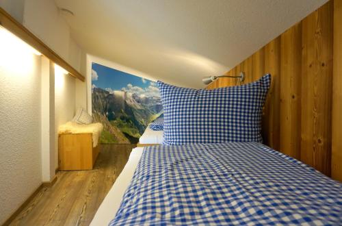 een slaapkamer met een bed met een blauw en wit geruit kussen bij Ferienwohnung am Frohmarkt in Oberstdorf