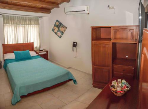 ein Schlafzimmer mit einem Bett und einer Kommode in einem Zimmer in der Unterkunft Hotel Casa Aragon in Cartago