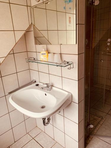 a bathroom with a sink and a mirror on the wall at Pension Stürrad in Neuharlingersiel